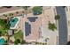 An aerial view shows the home's roof with solar panels, pool, and well-kept landscaping at 14161 W Poinsettia Dr, Surprise, AZ 85379