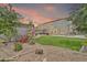Expansive backyard with a lush lawn, patio area, and garden featuring a charming desert landscape at 14161 W Poinsettia Dr, Surprise, AZ 85379