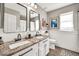 Bathroom featuring double sinks, granite countertops, and wainscoting at 14161 W Poinsettia Dr, Surprise, AZ 85379