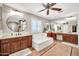 Bright bathroom featuring double sinks, a soaking tub, and a ceiling fan for a relaxing atmosphere at 14161 W Poinsettia Dr, Surprise, AZ 85379
