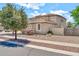 Side view of a well-maintained two-story home with a low wall, featuring desert landscaping at 14161 W Poinsettia Dr, Surprise, AZ 85379
