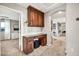 Hallway featuring built-in cabinets, a desk, and arched doorways to other rooms at 14161 W Poinsettia Dr, Surprise, AZ 85379