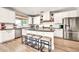 Open kitchen with island seating, stainless appliances, and bright white cabinetry at 14161 W Poinsettia Dr, Surprise, AZ 85379