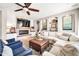 Bright living room with a stone fireplace, large TV, and stylish decor at 14161 W Poinsettia Dr, Surprise, AZ 85379