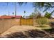 Gated backyard entrance surrounded by desert landscaping, offering privacy and security at 1454 W Capri Ave, Mesa, AZ 85202