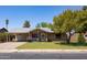 Charming single-story home with a well-manicured lawn and a cozy front porch with beautiful plants in front at 1454 W Capri Ave, Mesa, AZ 85202