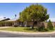 Charming single-story home with a well-manicured lawn and a cozy front porch with beautiful plants in front at 1454 W Capri Ave, Mesa, AZ 85202
