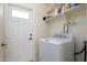 Laundry room equipped with a washing machine, shelving, and a door for added convenience at 1454 W Capri Ave, Mesa, AZ 85202