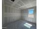 Bright bedroom under construction with drywall and one window, featuring recessed lighting and smooth concrete flooring at 16174 W Bajada Rd, Surprise, AZ 85387
