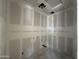 Bright laundry room under construction with drywall and recessed lights, featuring smooth concrete flooring at 16174 W Bajada Rd, Surprise, AZ 85387