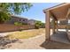 A home with a covered patio that looks out over a yard with a gravel perimeter and block wall at 17419 W Elaine Dr, Goodyear, AZ 85338
