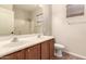 Bright bathroom featuring a double sink vanity, large mirror, and shower with a beige and white color scheme at 17419 W Elaine Dr, Goodyear, AZ 85338