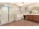 Bathroom featuring a glass-enclosed shower, soaking tub, vanity with wood cabinets, and tiled floors at 17419 W Elaine Dr, Goodyear, AZ 85338