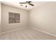 A neutral toned bedroom is carpeted and has a window with wood-tone blinds and a ceiling fan at 17419 W Elaine Dr, Goodyear, AZ 85338