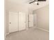 A neutral toned bedroom is carpeted and has double door closet with white doors and black knobs at 17419 W Elaine Dr, Goodyear, AZ 85338