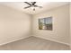A neutral toned bedroom is carpeted and has a window with wood-tone blinds and a ceiling fan at 17419 W Elaine Dr, Goodyear, AZ 85338