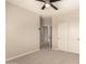 A neutral toned bedroom is carpeted and has double door closet with white doors and black knobs at 17419 W Elaine Dr, Goodyear, AZ 85338