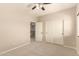 A neutral toned bedroom is carpeted and has double door closet with white doors and black knobs at 17419 W Elaine Dr, Goodyear, AZ 85338