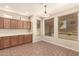 Inviting dining area with natural lighting, wood cabinets, tiled floor, and adjacent kitchen at 17419 W Elaine Dr, Goodyear, AZ 85338