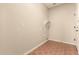 The laundry room has tile flooring and neutral colored walls with a white shelf at 17419 W Elaine Dr, Goodyear, AZ 85338