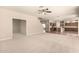 Expansive living room features neutral carpeting, ceiling fan, and seamless transition to the kitchen area at 17419 W Elaine Dr, Goodyear, AZ 85338