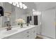 Bathroom featuring a dual sink vanity, framed mirrors, and a glass-enclosed shower at 18119 W Spencer Dr, Surprise, AZ 85374