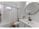Bathroom featuring a shower-tub combo, and a modern sink with a round mirror at 18119 W Spencer Dr, Surprise, AZ 85374
