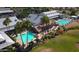 Aerial view of community center with pools, slide, palm trees, and landscaping at 18119 W Spencer Dr, Surprise, AZ 85374