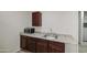 Wet bar area with granite countertops, dark wood cabinetry, a stainless steel sink, and a microwave at 1911 N 42Nd Ave, Phoenix, AZ 85009