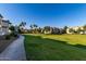 A long stretch of grassy common area leads to multiple apartment buildings on a sunny day at 1941 S Pierpont Dr # 1037, Mesa, AZ 85206
