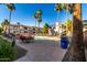 Swimming pool surrounded by lounge chairs, umbrellas, and apartment buildings on a sunny day at 1941 S Pierpont Dr # 1037, Mesa, AZ 85206