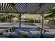 The backyard features a covered patio with a swing and cushions, a swimming pool, and desert landscaping at 1953 E Lafayette Ave, Gilbert, AZ 85298