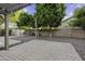 An outdoor patio area showcases beautiful landscaping with mature trees and charming pavers in a private backyard at 1953 E Lafayette Ave, Gilbert, AZ 85298