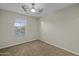 This bedroom features carpet flooring, a ceiling fan, neutral walls, and a window at 1953 E Lafayette Ave, Gilbert, AZ 85298
