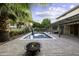 Private backyard featuring a sparkling pool, fire pit, covered patio, and lush landscaping at 1953 E Lafayette Ave, Gilbert, AZ 85298