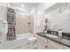 Bathroom with a shower-tub combo, neutral tiling, and a vanity with granite countertop and white cabinetry at 20438 W Calle Encorvada --, Buckeye, AZ 85396