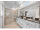 Bright bathroom featuring a dual sink vanity with granite countertop and a spacious glass-enclosed shower with seating at 20438 W Calle Encorvada --, Buckeye, AZ 85396