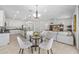 Open concept dining area featuring a modern table set, seamlessly connected to the kitchen and living room at 20438 W Calle Encorvada --, Buckeye, AZ 85396