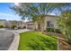 A beautifully landscaped front yard with synthetic grass, desert foliage, and a view of two neighboring homes at 20438 W Calle Encorvada --, Buckeye, AZ 85396