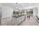Open-concept kitchen featuring an island with sink, stainless steel appliances, and view of the dining and living area at 20438 W Calle Encorvada --, Buckeye, AZ 85396