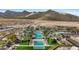 Aerial view of cascading community pools lined with palm trees and mountain views at 20438 W Calle Encorvada --, Buckeye, AZ 85396