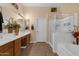 Bathroom featuring dual sinks, a soaking tub, and glass-enclosed shower at 2069 E Winchester Way, Chandler, AZ 85286