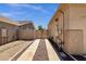 View of driveway between two homes with wood gate and gravel landscaping at 2069 E Winchester Way, Chandler, AZ 85286
