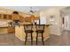 Traditional kitchen featuring wood cabinets, tile floors, granite countertops, and two breakfast bar stools at 2069 E Winchester Way, Chandler, AZ 85286