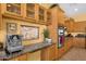 Kitchen featuring wood cabinets, stainless steel appliances, granite countertops, and a breakfast bar at 2069 E Winchester Way, Chandler, AZ 85286