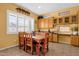 Eat-in kitchen features a wooden table with seating for six, wooden cabinets, and large bright windows at 2069 E Winchester Way, Chandler, AZ 85286