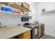 Laundry room with overhead storage, washer and dryer, and tile flooring at 2069 E Winchester Way, Chandler, AZ 85286