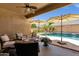 Covered patio with seating, ceiling fan and view of landscaped yard and pool at 2069 E Winchester Way, Chandler, AZ 85286
