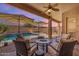 Inviting covered patio with comfortable seating area and ceiling fan overlooking the pool at 2069 E Winchester Way, Chandler, AZ 85286