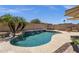 Beautiful blue pool with rock waterfall feature, lush palm trees and desert landscaping at 2069 E Winchester Way, Chandler, AZ 85286